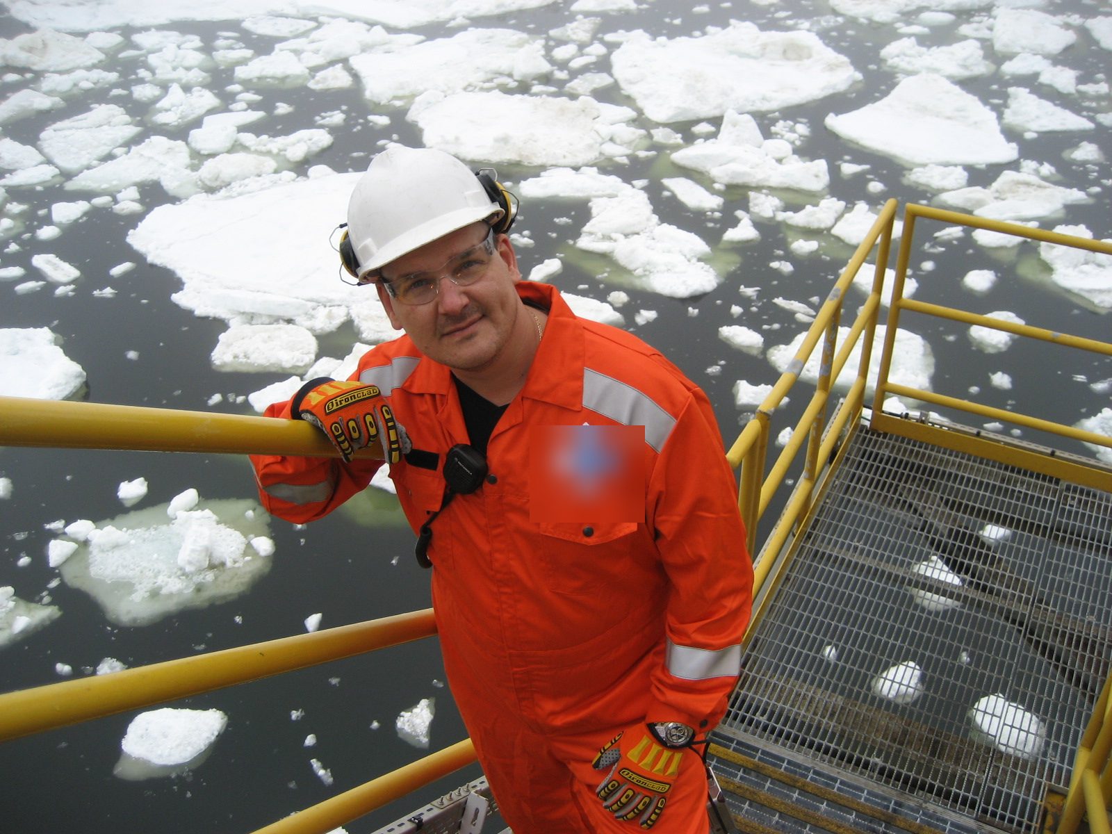 István Giblák on an Arctic offshore oil and gas platform surrounded by pack ice — cold-climate winterization work